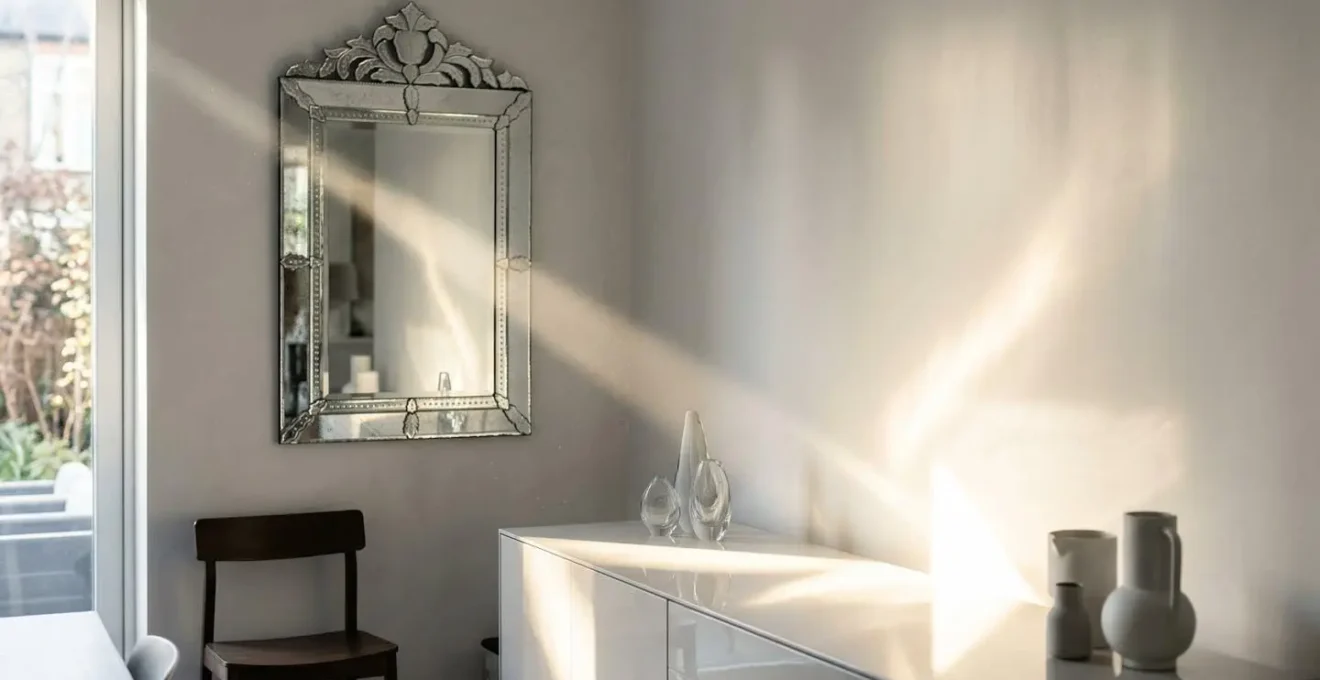 Séquence de réflexion lumineuse entre miroir, meuble laqué et mur satiné dans un salon